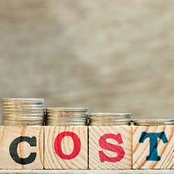 wooden blocks that spell cost with coins on them