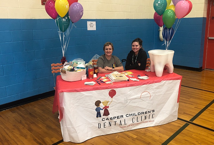 Two dental team members in a booth at community event