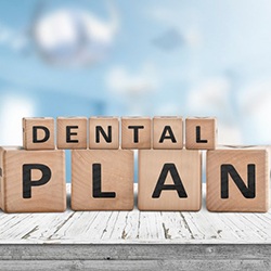a stack of wooden blocks spelling out dental plan