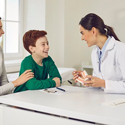 a dentist explaining something to a child patient