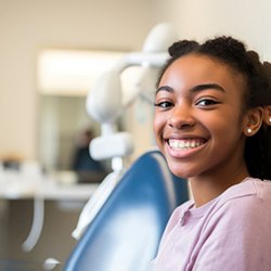 Smiling teen girl in dental treatment chair