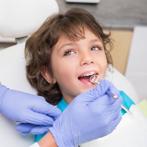 A pediatric dentist examining a little boy’s teeth