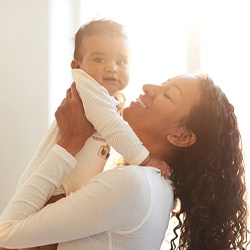 A mother and her baby smiling after seeing a pediatric dentist in Casper