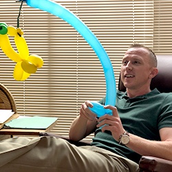 Dr. Ryne holding a fishing pole made of balloons