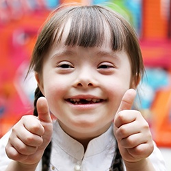 Young girl smiling and giving thumbs up