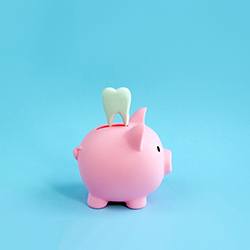 a piggy bank with a tooth above it