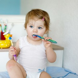 baby with toothbrushes