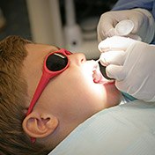 Young boy in sunglasses receiving dental treatment