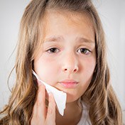 Young girl holding her cheek in pain