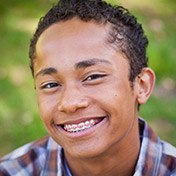 Preteen boy with braces smiling outdoors