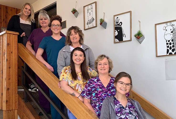 Dental office team members standing on steps of stairs