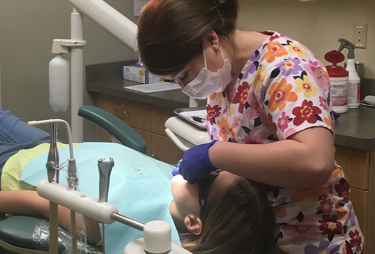 Dental team member treating patient