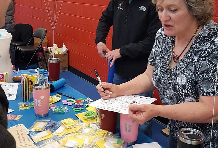 Team member showing child how to play a game at community event