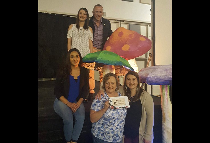 Dentist and dental team member posing with cut outs at community event