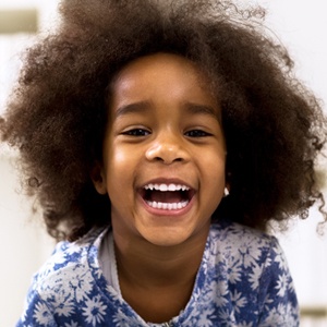 Little girl with healthy smile after dental sealant treatment