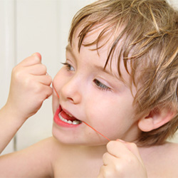 Little boy flossing teeth