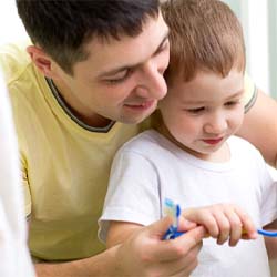 Father teaching child how to brush their teeth