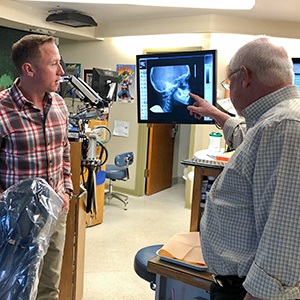 Dr. Roy and Dr. Ryne looking at dental x-rays on computer
