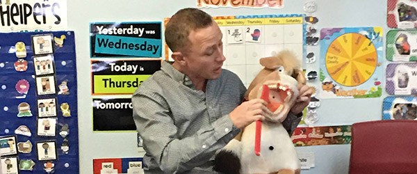 Pediatric dentist in Casper showing classroom of kids how to brush teeth