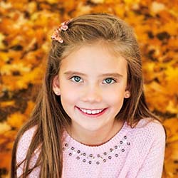 Girl smiling among leaves in Casper