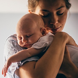 Mother holding sleeping infant