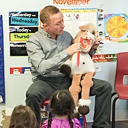 Dentist demonstrating brushing technique for kids