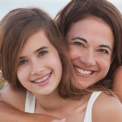 Smiling girl with braces posing with her mother
