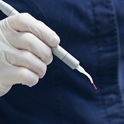 Pediatric dentist holding dental laser