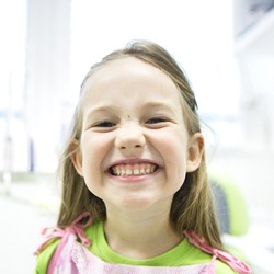 young girl smiling in dental chair