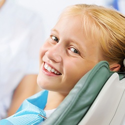 Smiling young girl in dental exam chair