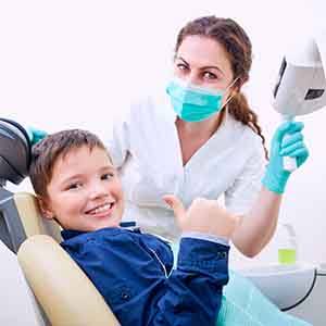 Young patient giving thumbs up in preparation for tooth exposure in Casper