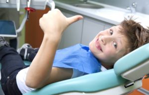 A child giving a thumbs up at his dental appointment.