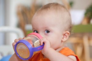 a baby drinking from a sippy cup