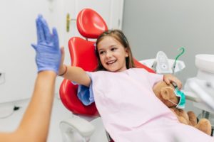 Young girl high-fiving her Casper children's dentist during first appointment