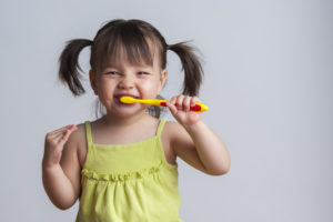 Little girl brushing teeth as recommended by Casper children's dentist