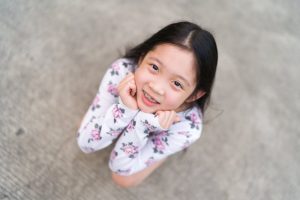 child with braces smiling and looking up