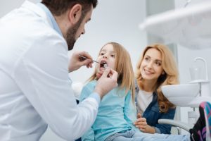 Mother and daughter smiling during her first dental visit