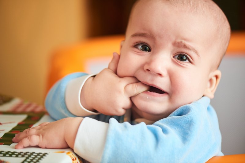 teething baby biting fingers