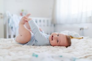 Baby smiling while lying in bed
