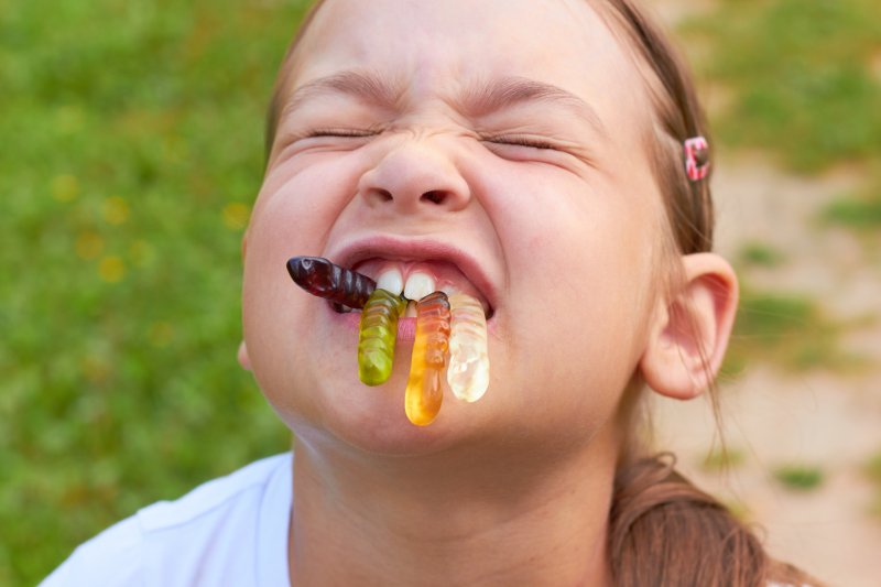 A child eating gummy worms.