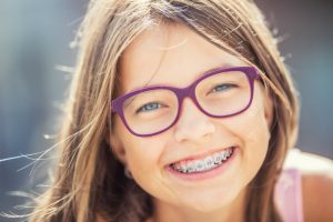 a girl smiling happily with her orthodontic treatment