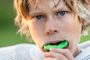 Young boy inserting a mouthguard