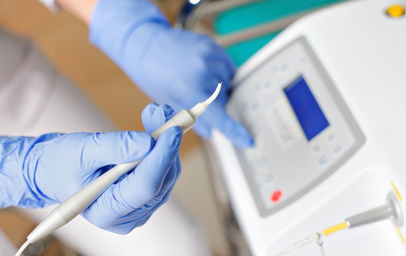 dentist holding a soft tissue laser